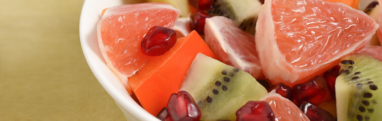 Pieces of fruit in a white plate close up