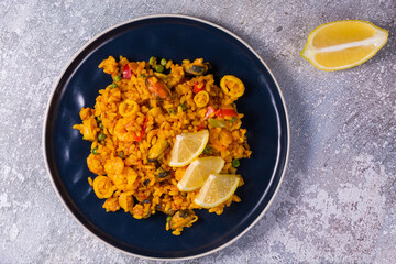 Freshly cooked seafood paella on a blue plate
