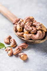Cashew nuts in spoon top view. Healthy raw nuts of cashew fruit. Tasty cashew nuts. The cashew tree is a tropical evergreen tree that produces the cashew seed and the cashew apple.