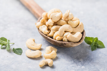 Cashew nuts in spoon top view. Healthy raw nuts of cashew fruit. Tasty cashew nuts. The cashew tree is a tropical evergreen tree that produces the cashew seed and the cashew apple.