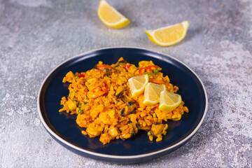 Freshly cooked seafood paella on a blue plate