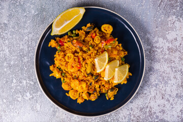 Freshly cooked seafood paella on a blue plate