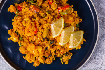 Freshly cooked seafood paella on a blue plate