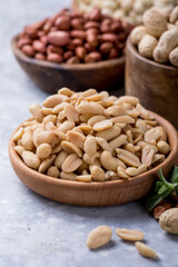 Roasted salted peanuts. Crispy nuts in bowl on stone table.