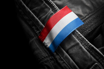 Tag on dark clothing in the form of the flag of the Netherlands
