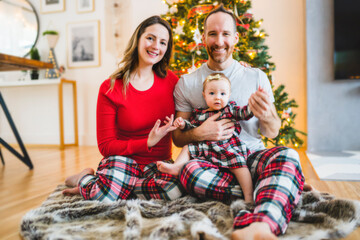 Christmas family with baby close to a tree