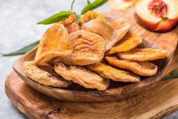 Dried fruits and Fresh peaches with leaves on stone background