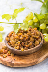 Golden raisins  in bowl on stone background, table top view. Dried fruit, healthy snack food
