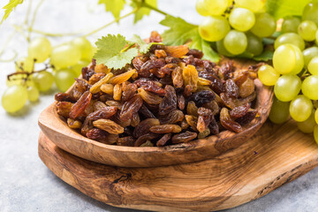 Golden raisins  in bowl on stone background, table top view. Dried fruit, healthy snack food