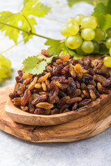 Golden raisins  in bowl on stone background, table top view. Dried fruit, healthy snack food