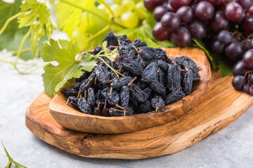 Black raisins  in bowl on stone  background, table top view. Dried fruit, healthy snack food