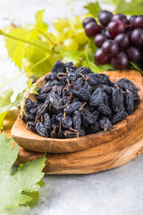 Black raisins  in bowl on stone  background, table top view. Dried fruit, healthy snack food