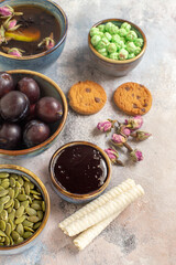 front view cup of tea with plums and candies on a light background dessert sweet biscuit
