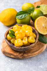Сandied fruit, dried kumquat  with lemon flavor in bowl on stone table background.