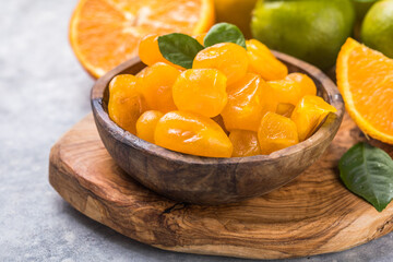 Сandied fruit, dried kumquat  with orange flavor in bowl on stone table background.