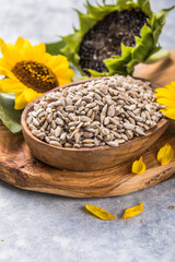 Sunflower seeds in a small plate with sunflower plant. Healthy vegetarian protein nutritious food.