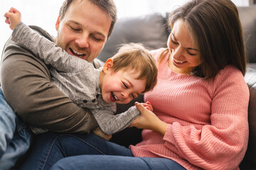 Obraz premium happy family mother and father having fun with child son at home
