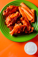 Chicken wings. Chicken wings served spicy buffalo wing sauce and honey barbecue sauce. Served with ranch dressing, blue cheese, celery and carrots. Classic American style bar or pub favorite fare.