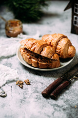 Croissant with caramel and walnuts.Christmas dish on gray background