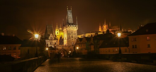 Fototapeta na wymiar Panoramic night view to the illuminated skyline of the historic Prague castle with the famous St. Vitus Cathedral and gothic bride tower.