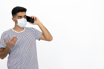 Young man wearing a white striped shirt. He's wearing a medical mask. He has a cell phone. White background. Isolated image.