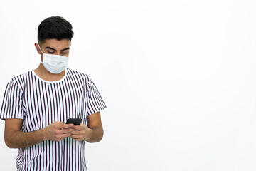 Young man wearing a white striped shirt. He's wearing a medical mask. He has a cell phone. White background. Isolated image.