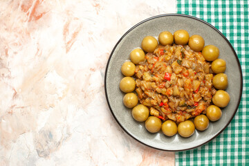 top view roasted eggplant salad on oval plate on nude background free space