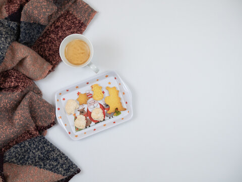Christmas composition. Scarf with cup of coffee and christmas cakes on white background. Flat lay, top view.