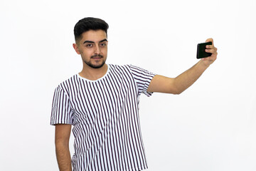 Young man with a phone in hand. Wearing a white striped T-shirt. Got short hidden. White background. Isolated image.