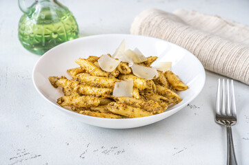 Portion of penne pasta with pesto sauce