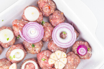 raw meat balls with vegetables and microgreens isolated on white