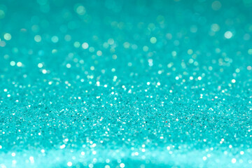 Teal abstract glitter background. Shallow depth of field, blurred bokeh effect.