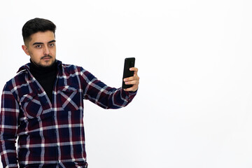 Young man wearing a dark striped shirt.  He has a phone.He has a dirty beard White background. Isolated image. 