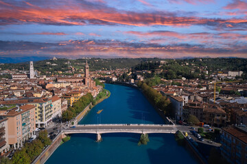 Fototapeta premium Verona aerial panoramic view. View of the historic city center along Adige river in Verona, Italy. Pink cumulus clouds in the sky. Beautiful panoramic view. Aerial photography with drone.