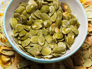 Peeled pumpkin seeds and husks in the background