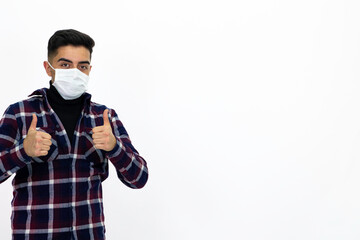 Handsome young man male model. He is wearing a medical mask and a dark checkered shirt.