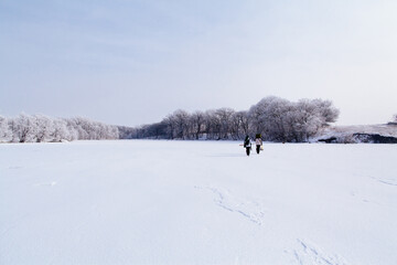 Fototapeta na wymiar winter fishermen on frozen snowy lake