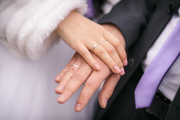 The bride and groom show wedding rings on their fingers