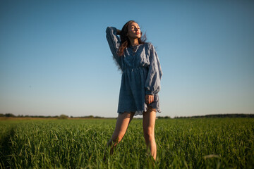 The girl walks in the field in summer.
