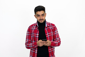 Teenager texting on the phone, wearing a red checkered shirt.