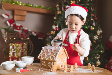 young girl making gingerbread house at home