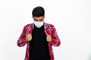 Young man wearing a medical mask. He wears a striped red shirt.