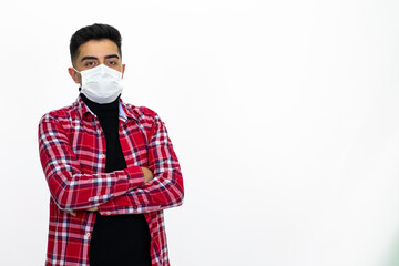 Young man wearing a medical mask. He wears a striped red shirt.