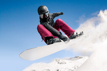 Snowboarder jumping through air with deep blue sky in background