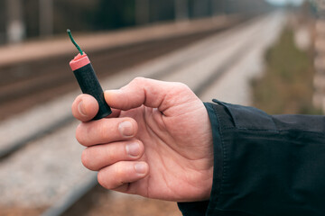The Firecracker in a Hand. Man Holding a Black Petard in His Hand. A Human with a Pyrotechnics...
