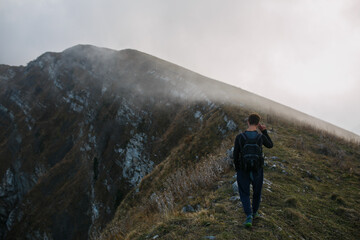 A guy with a backpack in the mountains.