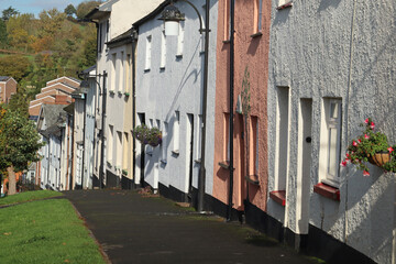 Fototapeta na wymiar A colourful terrace of cottages sloping downhill in Bradninch, Devon