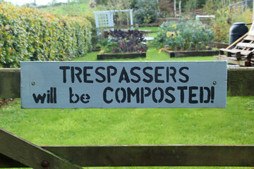 Humorous sign on a five bar gate warning Trespasses will be composted