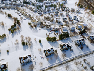 Aerial view of snowed in traditional housing suburbs in snow on trees in winter, panorama view