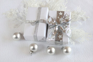 Christmas background with gifts, baubles and twigs in silver and white